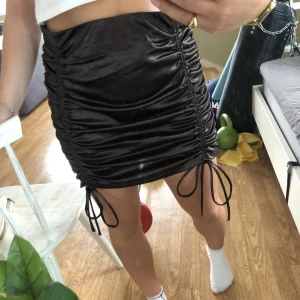 Siden kjol - En brun siden kjol med knytningar, snygg till fest eller lite mer finklätt, från hm 