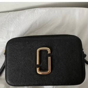 Marc jacobs väska - Säljer min fina Marc jacobsväska till super bra pris❤️Väskan är köpt här på plick och två små band saknas på väskan (skriv för bild) därför säljs den billigt❤️Bandet är äkta men själva väskan vet jag inte