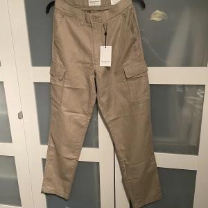 These Glory Days, cargobyxor i linne, - Helt nya med etiketter kvar. Fairfax cargobyxor i mjuk linne- och bomullsblandning från These Glory Days. De här snygga cargobyxorna har rakt ben och två stora påsydda lårfickor.  Straight fit Påsydda fickor Ord. Pris 899kr 52% Lin, 48% Bomull