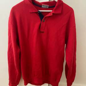 Röd tröja med detaljer i storlek L men passar S-L