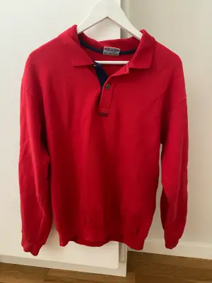 Röd tröja med detaljer i storlek L men passar S-L
