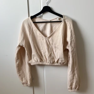Tröja - Gräddvit kortare tröja med v-ringning. Storlek M.