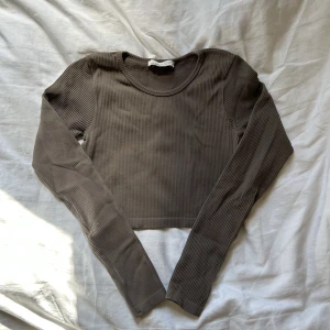 ribbad topp - brun ribbad topp från Pull&Bear. Jättevarm och skön inför hösten. Sitter tight men är jättestretchig! Bra skick! 