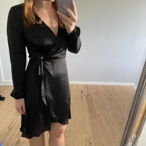 Klänning - Omlottklänning i satin. Köpt på Gina tricot.