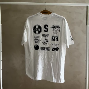 Stussy tröja - En stussy tröja med logotyper på ryggen.  Storlek Large.