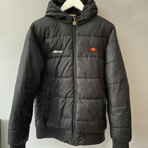Ellesse vinterjacka herr - Ellesse vinterjacka.  Strl M Litet, knappt synbart hål vid vänster ficka.