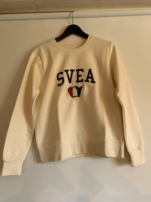 Vit tjocktröja från Svea - Vit tjocktröja från Svea. Trycket är broderat. Knappt använd! Storlek S. Krämvit färg. 