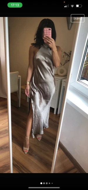 Balklänning  - Jättefin silvrig balklänning med knytning vid kragen. Använd en gång. Köpt från asos