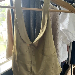 Halterneck topp - Guldfärgad halterneck topp Prislapp sitter kvar, aldrig använd.