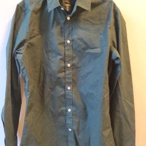 H&M Grön Slim Fit Skjorta  - Oanvänd, 2-3 år gammal. Storlek Small/170. Ganska skrynklig men lätt att stryka. 