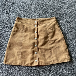 Kjol  - Brun kjol, inte äkta mocka. 