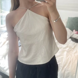 Halternecktopp  - Superfin halternecktopp i lite glittrigt material. Endast använd fåtal gånger. Skriv gärna privat för fler bilder.