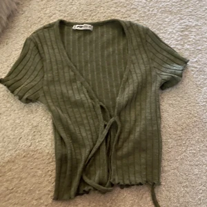 grön ribbad tröja med knyte  - inte använd mycket, är från new yorker och har knyte där framme! 
