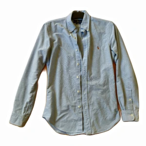Ralph Lauren Skjorta - Ljusblå skjorta köpt på Marty år 2017 för 1300kr. Condition 6/10, lite fläckar här och där men det syns ej tydligt. Storlek S