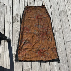 Orange blommönstrig kjol - Säljer nu min jättefina orangea kjol med blommönster och ett meshlager då den tyvärr är för liten för mig. Kjolen är köpt från Humana second hand och har en tajt passform med hög midja
