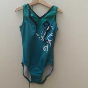 Gymnastikdräkt  - En tävlingsdräkt som är i bra skick med fina detaljer i glitter och olika typer av former, det står tyvärr inte vilken storlek dräkten har men den passar en tjej som är runt 10-12år. 
