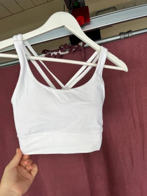 Lululemon topp - Nyskick, använd någon gång bara. Coola korsningar i ryggen, och snygg passform. Jag äger en exakt likadan, därför säljer jag denna. Köpte för 450kr
