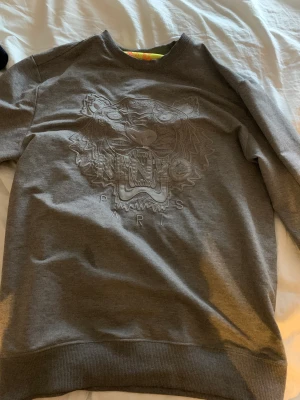Kenzo paris - Mörk grå kenzo Paris tröja storlek M, det är någon fett fläck på tröjan men jag tror att de går bort med vanish. Köparen står för frakten eller mötas upp. Vi diskuterar pris i DM