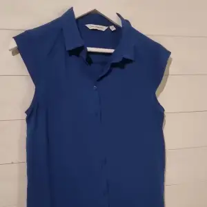 Fin blus i 100% polyester = helt skrynkelfri.  Lätt och skön att bära, för sig själv, eller under tröja eller kavaj. 