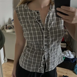 Väst - Rutig väst från Pret a Porter med volangdetaljer och knappar