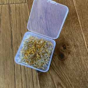 Hängen för örhängen - Paket med hängen för att kunna göra egna örhängen. Silver- och guldfärgade med plast-ploppar för baksidan.  Cirka 40 par 