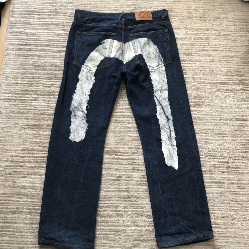 Ett par tvär feta baggy evisu jeans med  tryck på baksidan. Bra skick men använda  24 cm benöppning. Jeans & Byxor.