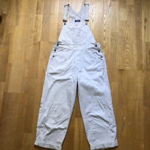 Vintage vita hängselbyxor  - Vintage hängselbyxor väldigt fina men har små fläckar på bakfickan från förra ägaren. 