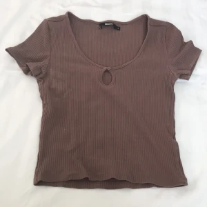 Brun topp - - Plagg: kortärmad Topp - Mönster: Inget - Färg: Brun - Storlek: S - Märke: Bikbok - Skick: Bra - Egenskaper: Knapp I framsidan, ribbad, stor urringning   Kontakta mig gärna vid frågor 💕 