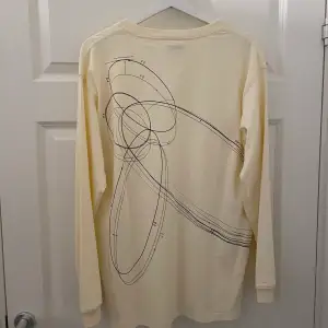 Långärmad tröja med motiv på baksidan från ett random märke.