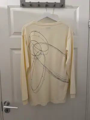 Långärmad tröja med motiv på baksidan från ett random märke.