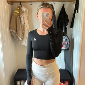 Sporttop - Sporttop från Adidas, öppen rygg och långa ärmar med ett hål för tummen 