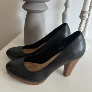 snygga skor med träklack! - supersnygga svarta klackskor med träklack från dinsko! endast använd 2-3 gånger 💓kan användas till middag som utgång 🤩har nån fläck på båda sulorna i skorna men det är inget man känner eller tänker på 💓 Storlek 39. 