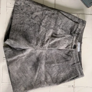 Dagmar shorts i mocka - Supersnygga shorts, hög midja i storlek 36. 100% lammskinn. Nyskick - endast legat i garderoben. Gråbrun färg som på bilderna  Dyra vid inköp