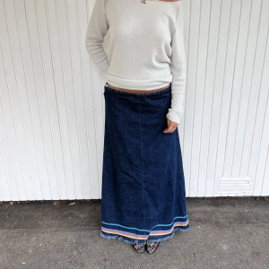 Jeanskjol med broderier nedtill - Jeanskjol med broderier nedtill, köpt vintage i Barcelona! Har en rosorband i midjan så den går att justera till mindre och större 