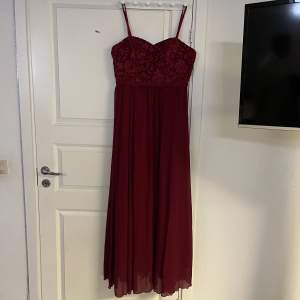 Vinröd klänning med blommig design på övre delen, från SHEIN i strl XL, trolig i storleken. aldrig använd.