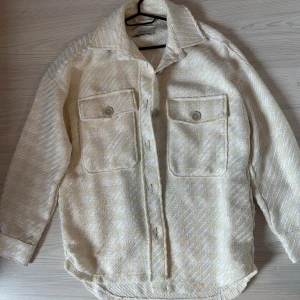 Ovesized kappa/jacka - Ovesized kappa/jacka i storlek S, den är benvit/gul i färgen och rak i passformen. Använd en gång, säljs för att den inte kommer till användning. orginalpris på asos var 399kr. Tillkommer med en extra knapp till fickorna. 