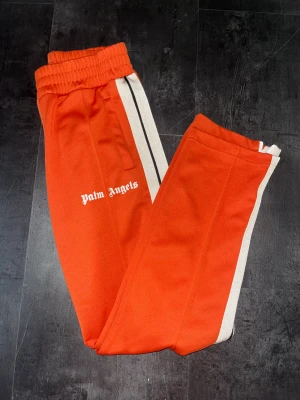 Palm Angels byxor - Säljer mina Palm Angels byxor (Orange) Skick: 10/10 Knappt använda, säljer pågrund av att jag aldrig använder dem. Taggen visar att det är äkta!