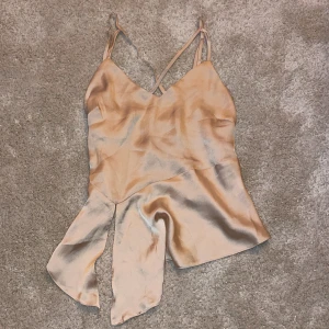 Silkestopp - Beige silkestopp med korsade band framtill och lite öppen rygg