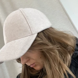 Beige keps - Beige lite ”lurvig” keps, från primark. Knappt använd så den är i toppenskick!  Justerbar med kardborre där bak.