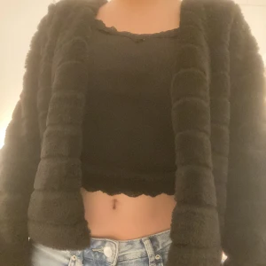 Svart pälsjacka - Så så så skön och lurvig jacka eller kofta! Säljer då den inte har använts mer än ungefär 3 gånger. Den har en knapp som man ser på andra bilden så man kan stänga koftan. Passar till fest tillfällen m.m! Från Gina Tricot!💕