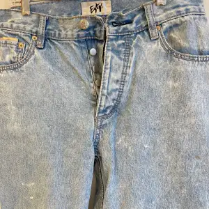 Baggy blå jeans, slitningar längst ner på byxbenet men inget som märks! 