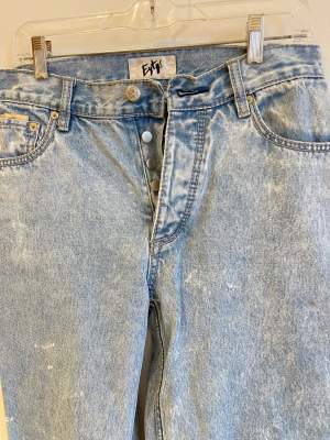 Baggy blå jeans, slitningar längst ner på byxbenet men inget som märks! 