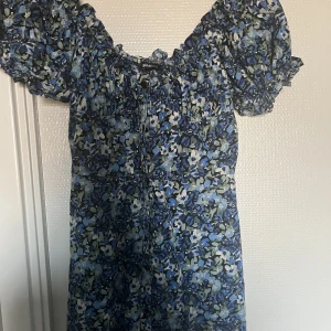 Blommig sommarklänning - Säljer min fina klänning från Gina som är använd Max 2 gånger så finns inget tecken på att klänningen använts. Klänningen går till ungefär innan knäna och har knappar längst med hela klänningens framsida. Passar xs/s💞köptes förra året för 400kr