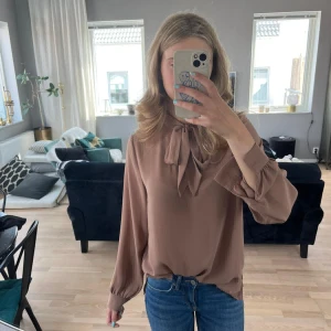 Blus med knyt - Söt blus i tunnt följsamt tyg. Knytes om man vill med rosett fram. 