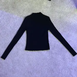 En fin ribbad långärmad tröja med lätt polokrage i storlek M. Den är väldigt fint skick och är sparsamt använd!