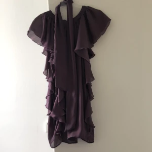 Söt LILA volangklänning med scarf - Supersöt volangklänning med matchande scarf. Mer lila färg än vad som syns på bild. Från Second Female Copenhagen. XS