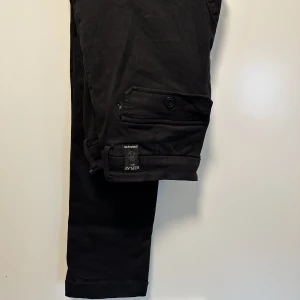 Replay / Cargo - Snygga Cargobyxor från Replay!  Snygg passform/slim.  Storleken är: 28 och är i stretch. OBS!: Gylfen går att knäppa, men sömmen har gått upp som håller fast spåret på gylfen, så när man dragit upp den så ser man ”gylfspåret”, övrigt bra skick men använt.