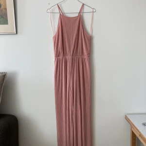 Byxdress - Gammelrosa och flowig byxdress från Monki. Nyskick. Strl S. Slutar strax ovanför anklarna på mig som är 163 cm lång. Strl: S. Material: Polyester.