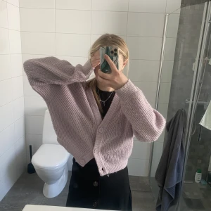 Ljuslila kosta - Vacker och mysig ljuslila kofta med knappar luftig men fortfarande värmande över en topp