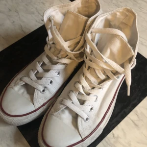 Vita converse  - Vita höga Converse i fint men använt skick. Köpta second hand men var tyvärr för stora för mig :( De är strl 41 och ett av snörena har knutar i slutet, men det är inget som påverkar skorna. Öppen för prisförslag/prutning och frågor!! 
